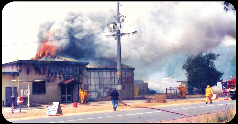 Dereel shop fire Dereel general store with fire and smoke billowing from roof and firefighters attempting to extinguish